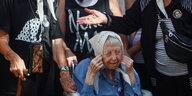 Eine alte Frau mit Kopftuch sitzt in einem Rollstuhl bei einer Demonstration in Argentinien