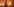 Kirsten Dunst steht mit einer Kamera inmitten orangenen Lichts
